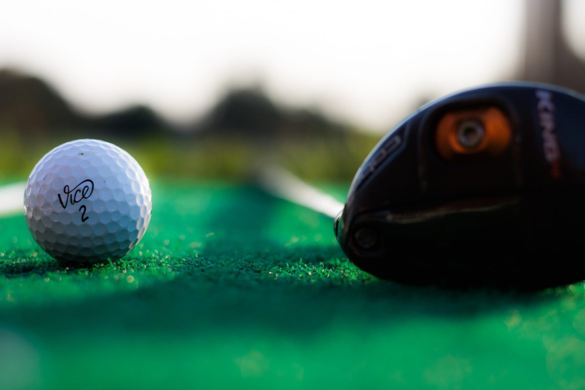 Golfball und Schläger.